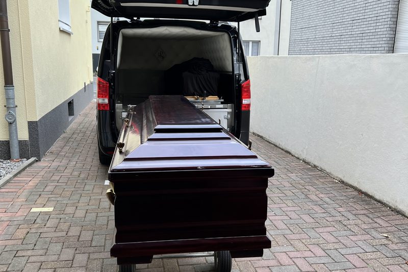 Труна на каталці біля ритуального мікроавтобуса — підготовка до репатріації тіла в Україну